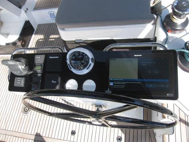 Slide: The Image of Control panel of 2025 Jeanneau Yacht 65 with navigation instruments and steering wheel. - 19