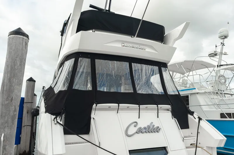 Slide: The Image of 2023 Sunseeker Manhattan 55 yacht docked, featuring sleek design and covered deck area. - 15