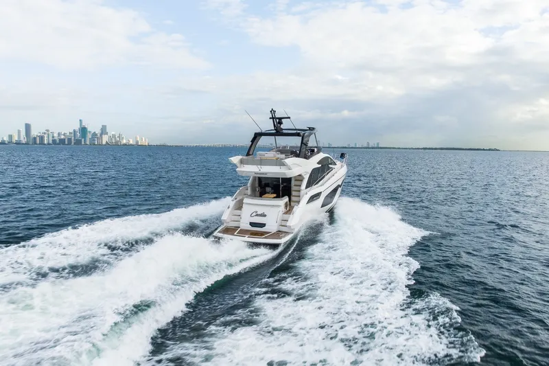 Slide: The Image of 2023 Sunseeker Manhattan 55 yacht cruising near city skyline on open water. - 1