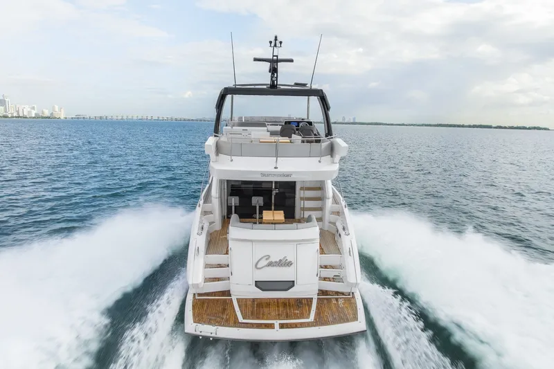 Slide: The Image of 2023 Sunseeker Manhattan 55 yacht cruising on open water, rear view. - 3