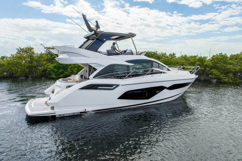 Slide: The Image of 2023 Sunseeker Manhattan 55 yacht cruising on a serene waterway. - 14