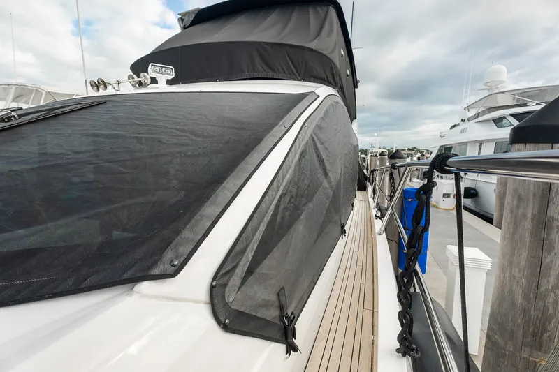 Slide: The Image of 2023 Sunseeker Manhattan 55 yacht docked, featuring sleek design and covered windows. - 20