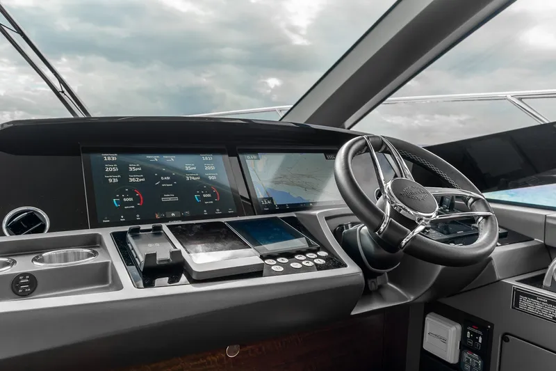 Slide: The Image of 2023 Sunseeker Manhattan 55 yacht helm with advanced navigation displays and sleek steering wheel. - 21