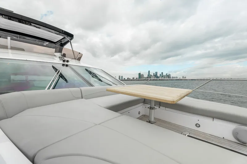 Slide: The Image of 2023 Sunseeker Manhattan 55 yacht with city skyline view, featuring luxurious seating and table. - 39