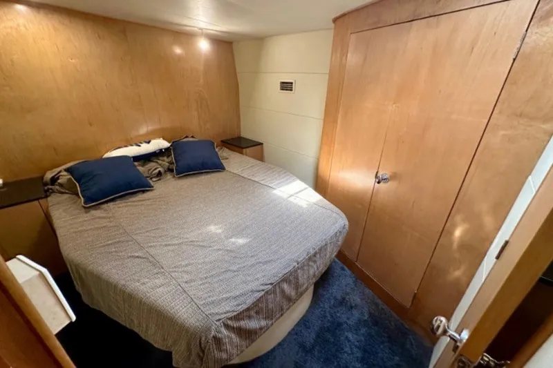 Slide: The Image of Cozy bedroom in 1985 Bertram 54 Convertible yacht with wood paneling and blue accents. - 22