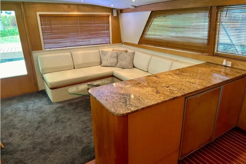 Slide: The Image of Luxurious interior of a 1985 Bertram 54 Convertible yacht with plush seating and wooden accents. - 17