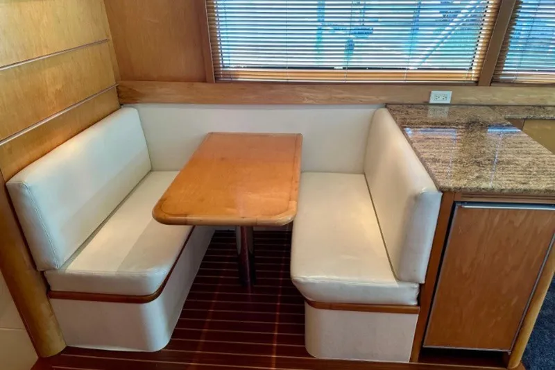 Slide: The Image of Interior of 1985 Bertram 54 Convertible yacht with cozy dining booth and wooden accents. - 19