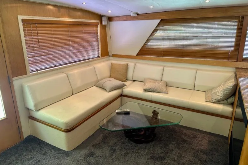 Slide: The Image of Interior of 1985 Bertram 54 Convertible yacht with plush seating and glass table. - 16