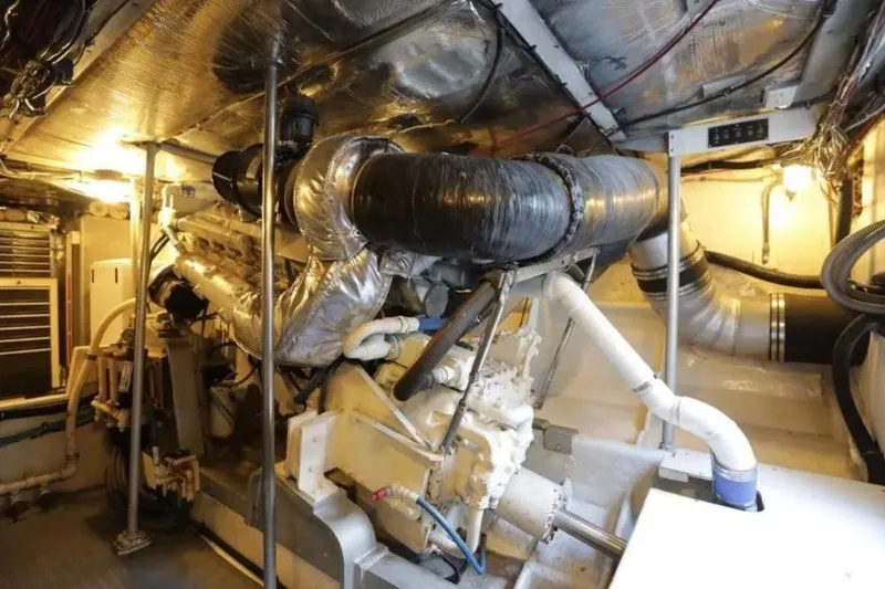 Slide: The Image of Engine room of a 1985 Bertram 54 Convertible yacht, showcasing machinery and piping. - 26