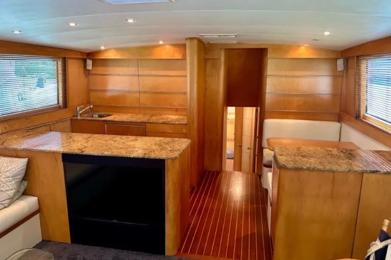 Slide: The Image of Luxurious interior of a 1985 Bertram 54 Convertible yacht with wood paneling and granite countertops. - 18