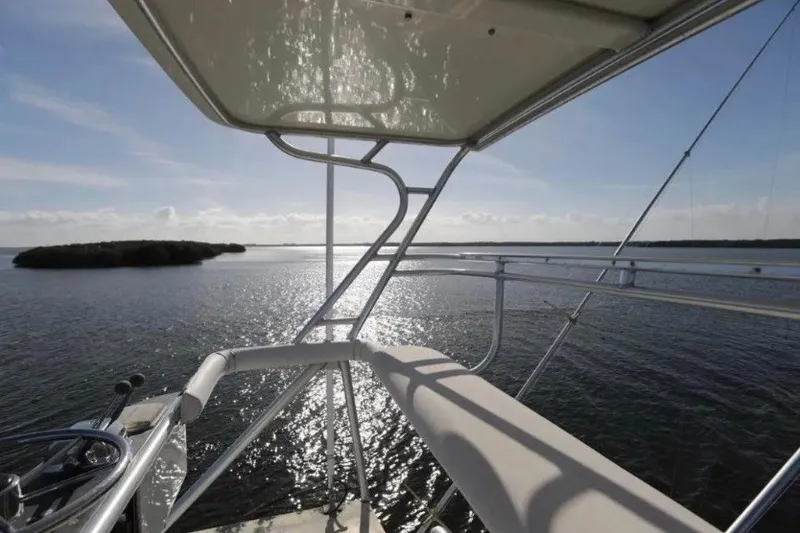 Slide: The Image of 1985 Bertram 54 Convertible yacht overlooking serene ocean waters at sunset. - 14
