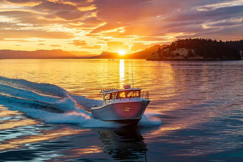 Slide: The Image of Ocean Sport 27 boat cruising at sunset, 2025 model, on serene waters. - 24