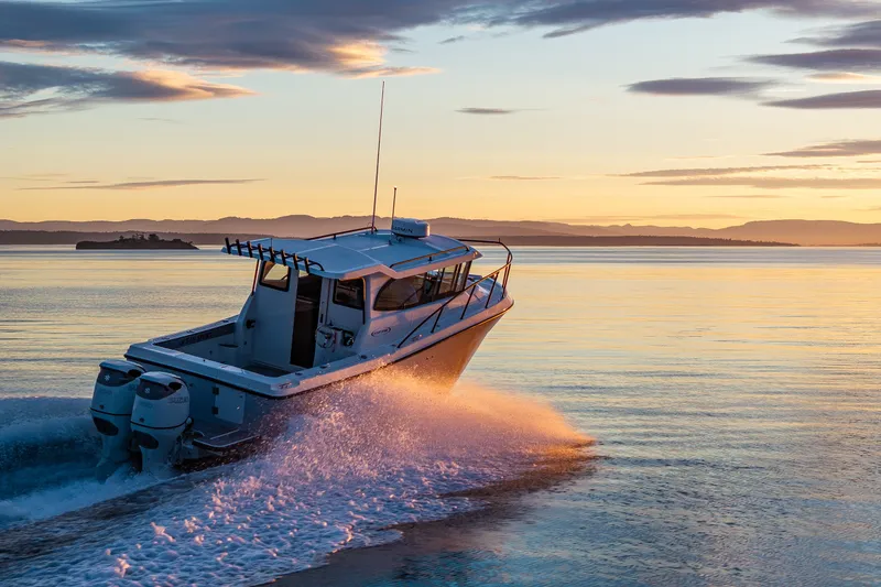Slide: The Image of Ocean Sport 27 boat cruising at sunset, 2025 model, on calm waters. - 26