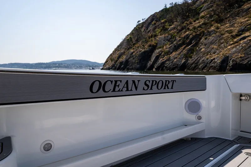 Slide: The Image of 2025 Ocean Sport 27 boat interior with scenic coastal backdrop. - 20