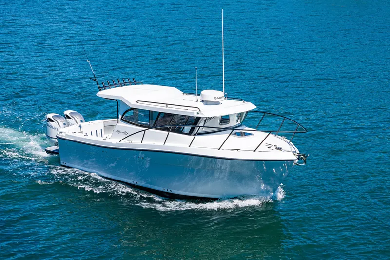 Slide: The Image of 2025 Ocean Sport 27 boat cruising on clear blue water. - 32