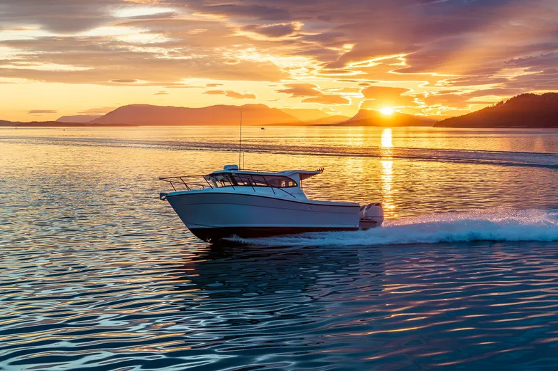 Slide: The Image of Ocean Sport 27 boat cruising at sunset, 2025 model, on tranquil waters. - 21