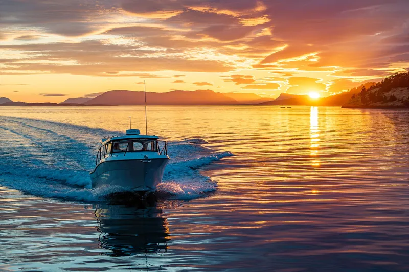 Slide: The Image of Ocean Sport 27 boat cruising at sunset on tranquil waters, 2025 model. - 25