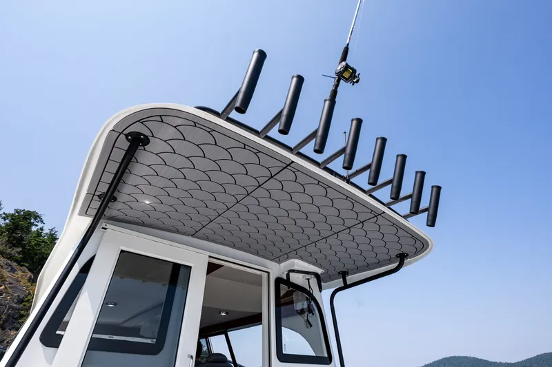 Slide: The Image of 2025 Ocean Sport 27 boat with rod holders and sleek design under clear blue sky. - 19