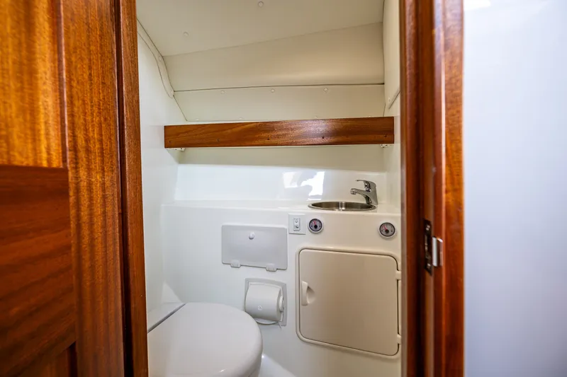 Slide: The Image of Compact bathroom in 2025 Ocean Sport 27 boat with wooden accents and modern fixtures. - 14