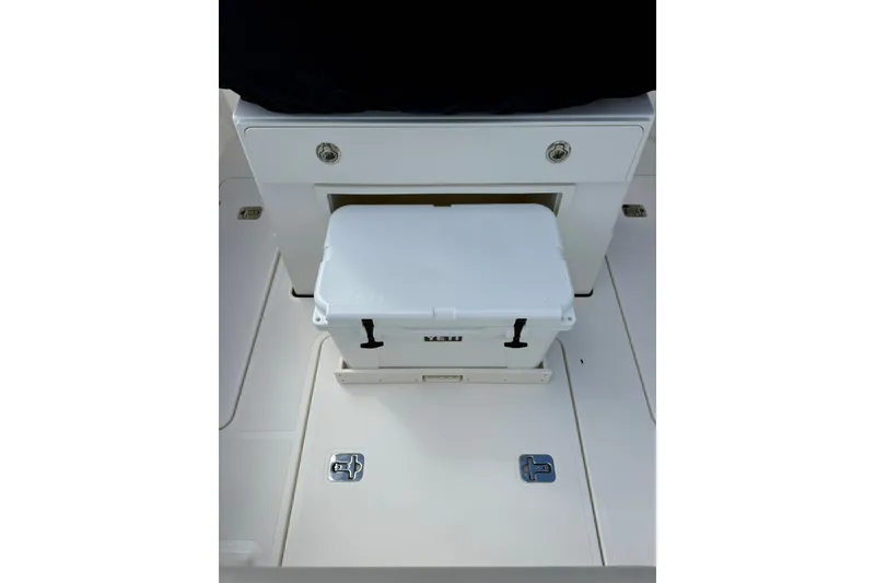 Slide: The Image of 2023 Pursuit S 248 Sport boat interior with white cooler and storage compartment. - 10