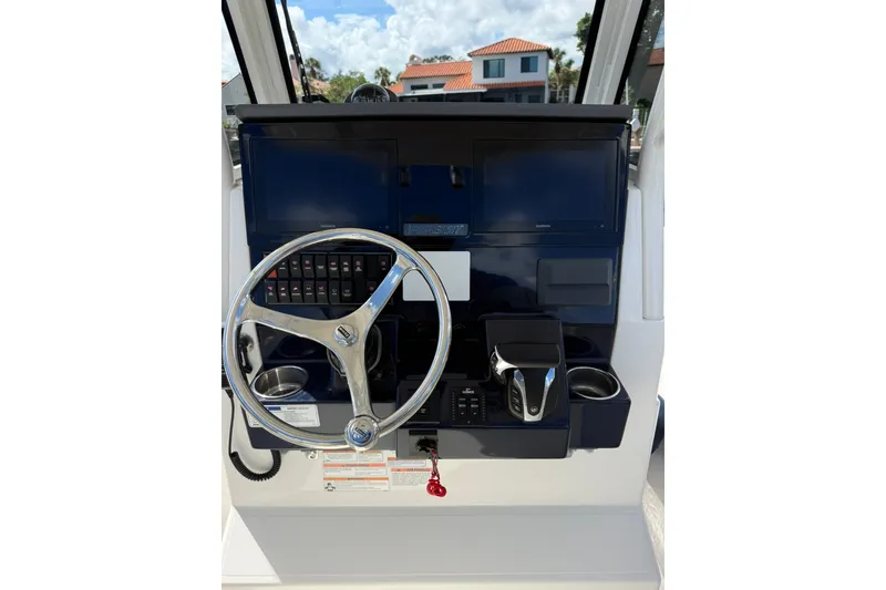 Slide: The Image of 2023 Pursuit S 248 Sport boat dashboard with steering wheel and controls. - 13