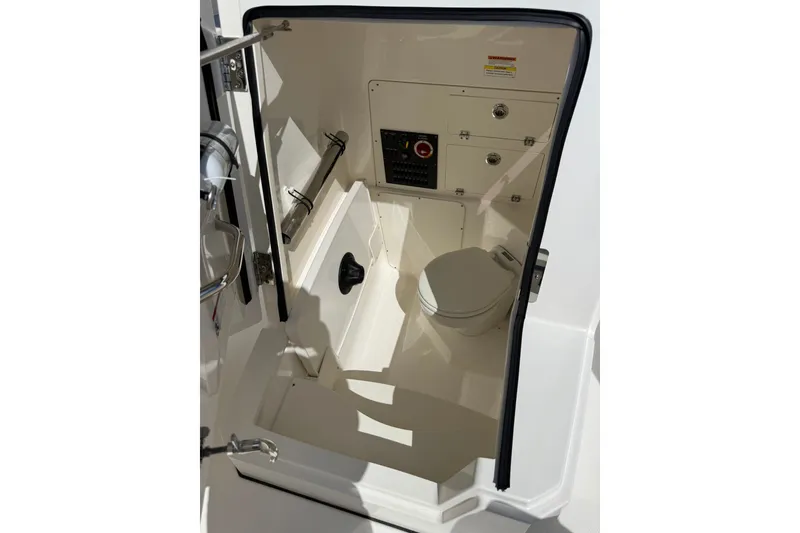 Slide: The Image of 2023 Pursuit S 248 Sport boat interior with compact marine toilet. - 26