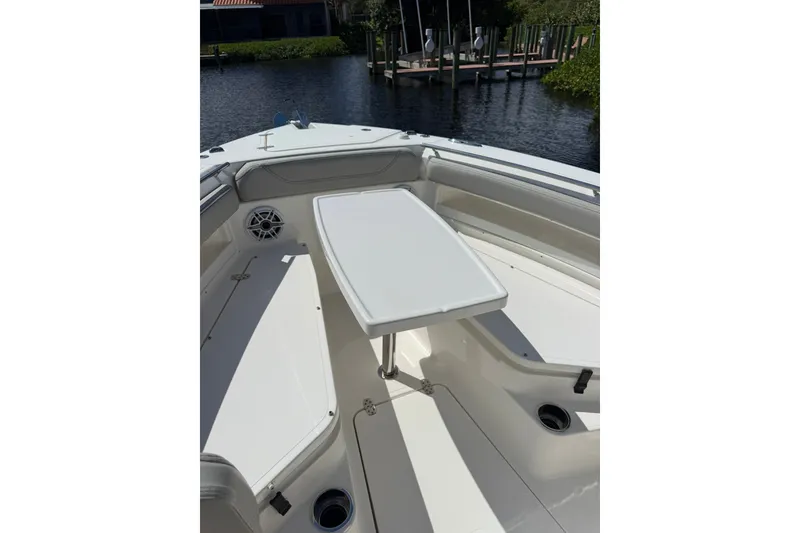Slide: The Image of 2023 Pursuit S 248 Sport boat interior with seating and table on calm water. - 29