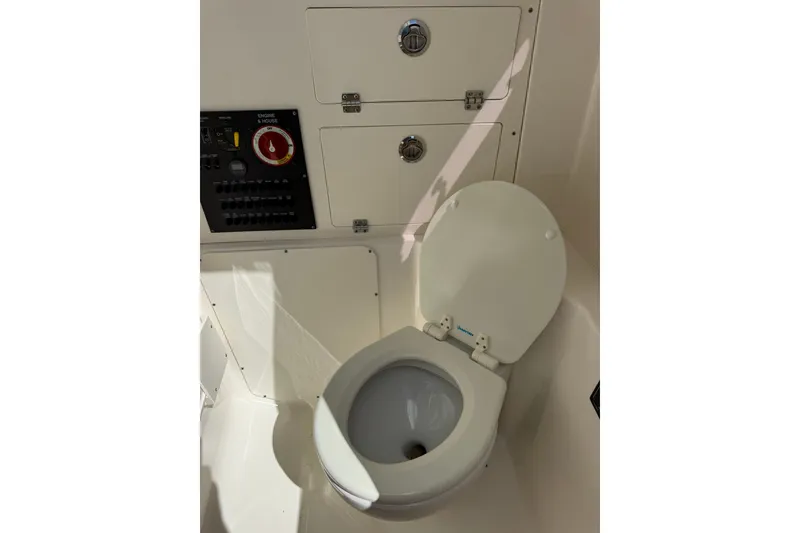 Slide: The Image of 2023 Pursuit S 248 Sport boat interior with toilet and control panel. - 28