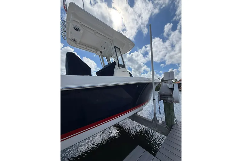 Slide: The Image of 2023 Pursuit S 248 Sport boat docked under a cloudy sky. - 2