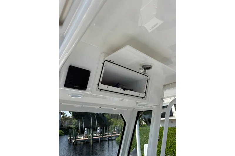 Slide: The Image of 2023 Pursuit S 248 Sport boat interior with storage compartment and Garmin speaker. - 19