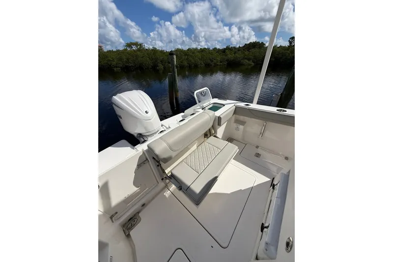 Slide: The Image of 2023 Pursuit S 248 Sport boat interior with seating and motor, under a cloudy sky. - 4