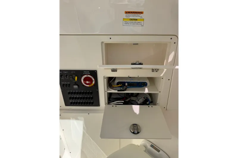 Slide: The Image of 2023 Pursuit S 248 Sport boat electrical panel and storage compartments. - 27