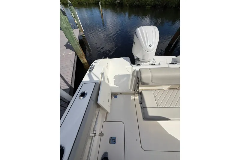 Slide: The Image of 2023 Pursuit S 248 Sport boat stern view with seating and outboard motor. - 6