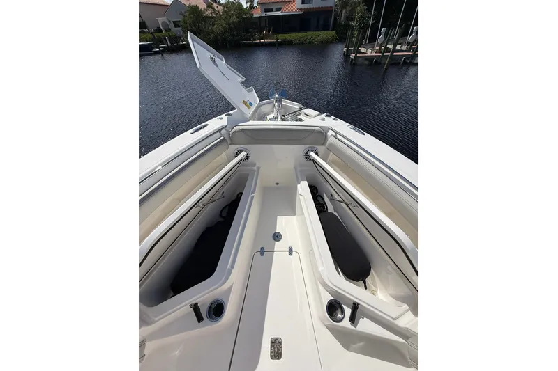 Slide: The Image of 2023 Pursuit S 248 Sport boat interior with open storage compartments on calm water. - 22