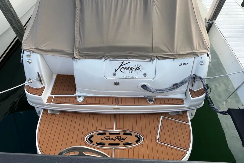 Slide: The Image of 2005 Sea Ray Sundancer 320 docked, featuring teak swim platform and covered seating area. - 4