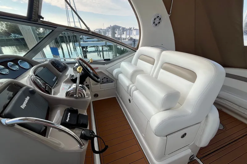 Slide: The Image of 2005 Sea Ray Sundancer 320 helm with white seating and modern navigation equipment. - 9