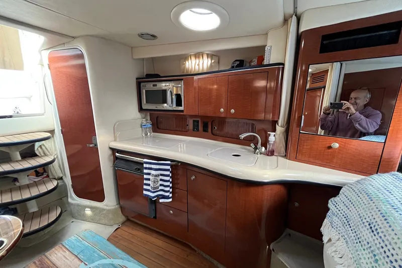 Slide: The Image of Interior of 2005 Sea Ray Sundancer 320 yacht with kitchenette and wooden cabinetry. - 22
