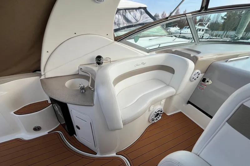 Slide: The Image of 2005 Sea Ray Sundancer 320 cockpit with seating, sink, and wood-style flooring. - 15