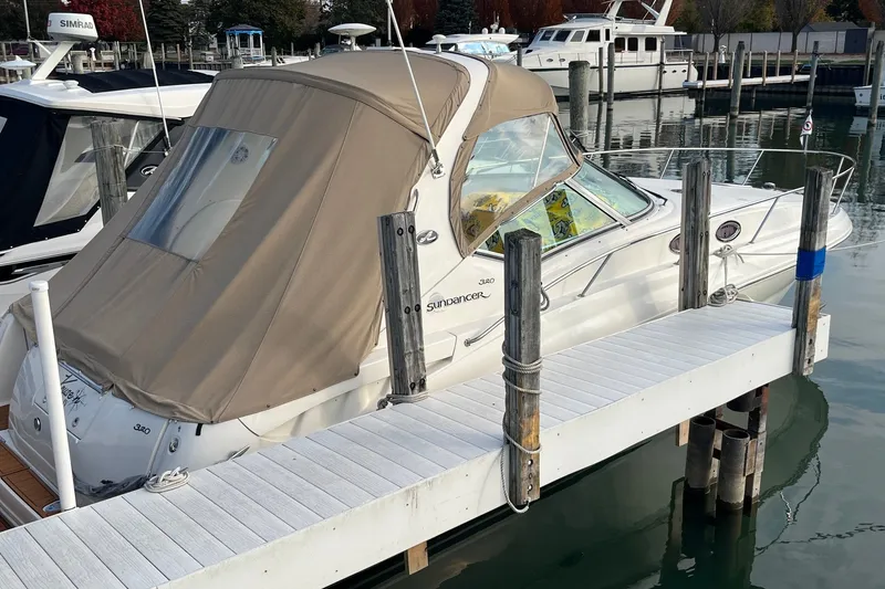 Slide: The Image of 2005 Sea Ray Sundancer 320 docked at marina with beige canopy. - 1