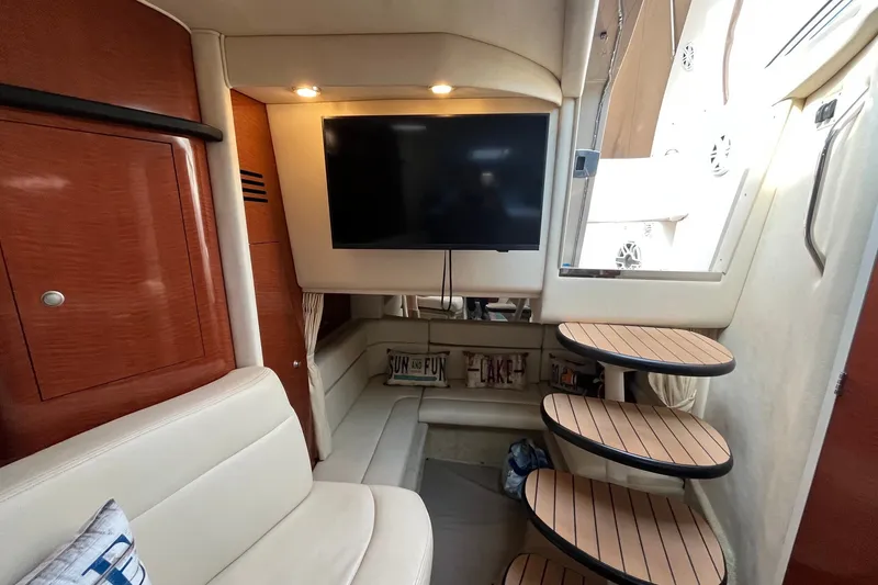 Slide: The Image of Interior of 2005 Sea Ray Sundancer 320 yacht with TV, seating, and wooden steps. - 26