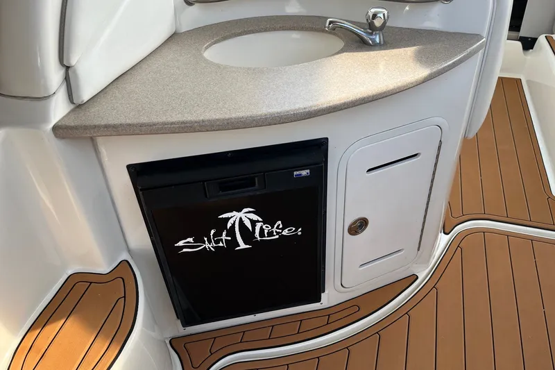 Slide: The Image of 2005 Sea Ray Sundancer 320 boat interior with sink, fridge, and teak flooring. - 18