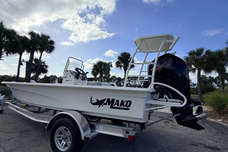Slide: The Image of 2026 Mako 18 Pro Skiff boat on trailer, parked near palm trees under blue sky. - 5