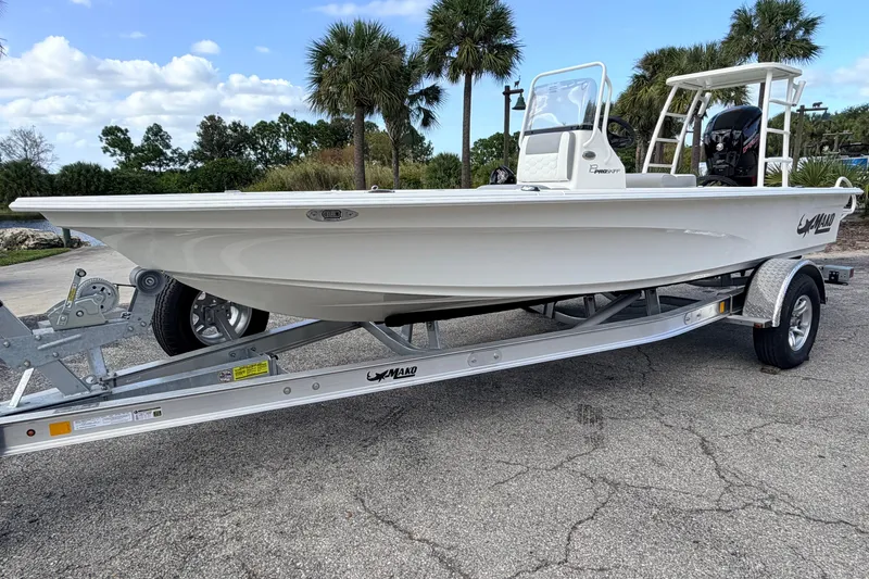 Slide: The Image of 2026 Mako 18 Pro Skiff boat on trailer, parked outdoors with palm trees in background. - 4