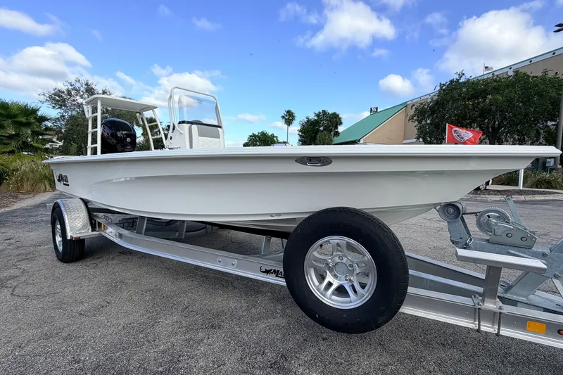 Slide: The Image of 2026 Mako 18 Pro Skiff boat on trailer, parked outdoors under blue sky. - 2