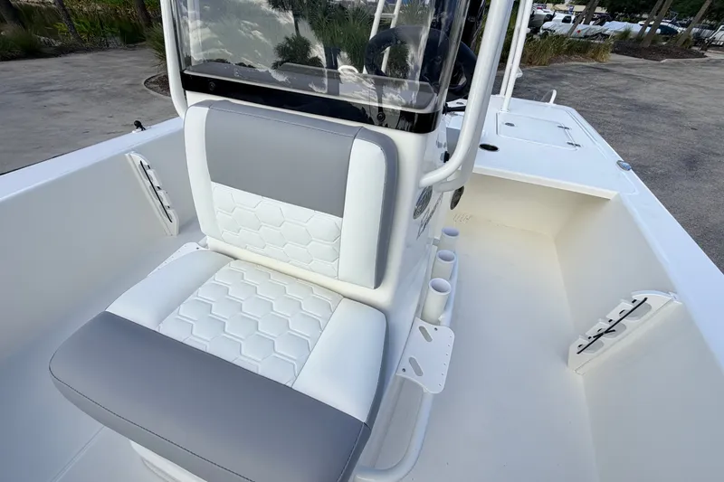 Slide: The Image of 2026 Mako 18 Pro Skiff boat interior with cushioned seating and rod holders. - 11