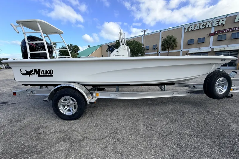 Slide: The Image of 2026 Mako 18 Pro Skiff boat on trailer, parked outside dealership. - 1