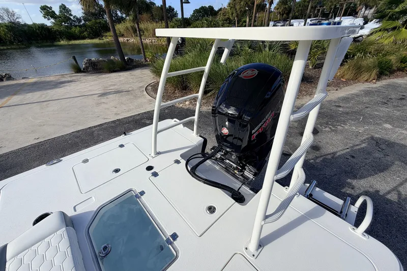 Slide: The Image of 2026 Mako 18 Pro Skiff boat with outboard motor, docked near a scenic lake. - 15