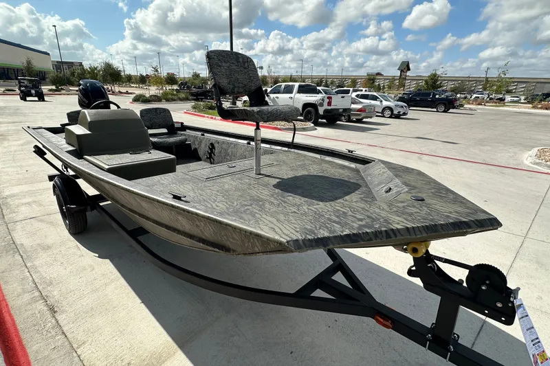 The Image of 2027 Tracker Grizzly 1754 SC boat on trailer in parking lot under cloudy sky. - 0