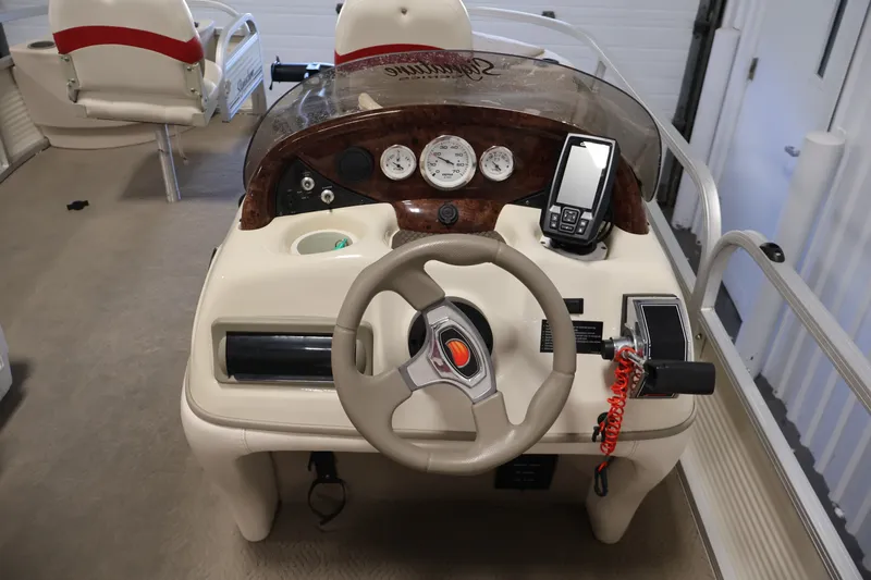 Slide: The Image of 2008 Sun Tracker Fishin' Barge 21 dashboard with steering wheel and navigation controls. - 15