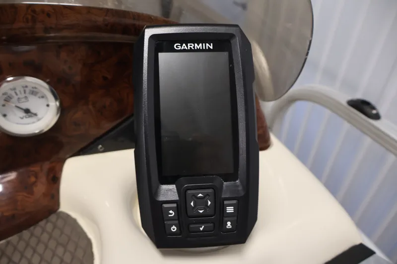 Slide: The Image of Garmin device on 2008 Sun Tracker Fishin' Barge 21 dashboard, next to a voltmeter gauge. - 19